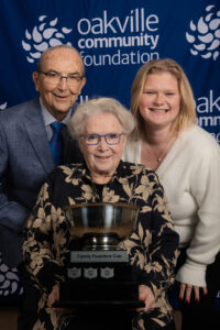 From left to right, Peter, Joanne and Ella Kenny pose with the Family Founders Cup in front of an Oakville Community Foundation banner.